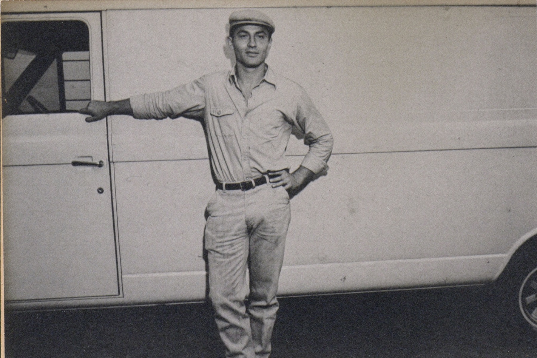 Black-and-white 1968 photograph of founder Frank Hartwell beside his panel van