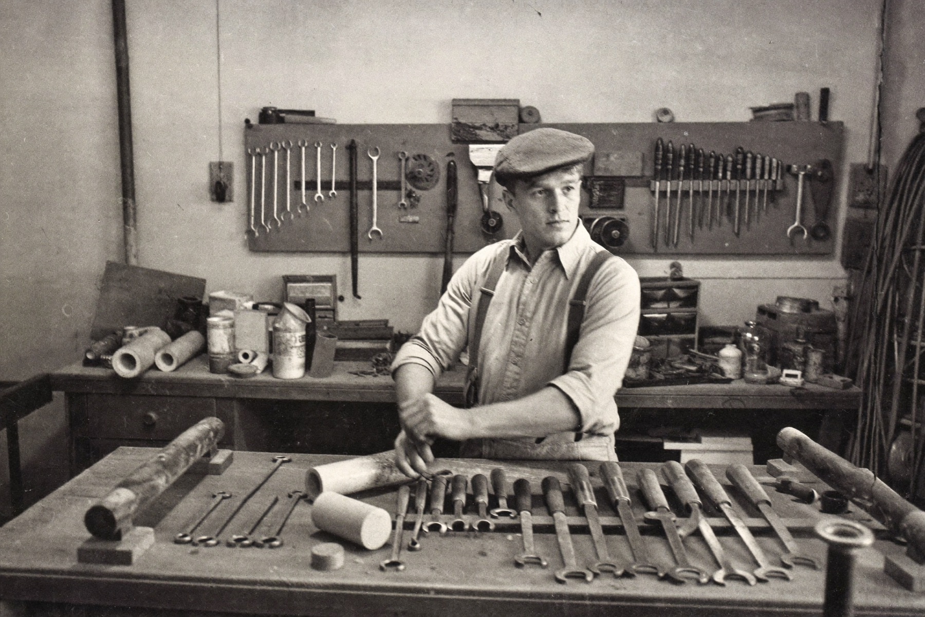 Staged black-and-white archival photograph of founder Frank Hartwell at his workbench, 1968